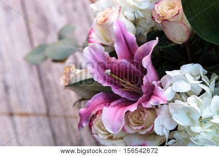 Wedding bouquet of white and pink flowers including roses, hydrangea, star gazer lilies and queen annes lace on a rustic table in the French countryside on Valentine's Day