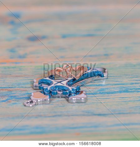 Wedding rings and coss on wooden table