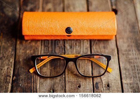 Glasses  Lie On The Dark Wooden Table.   Black Orange  Glasses