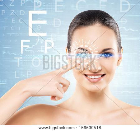 Beautiful woman with laser hologram and test vision table over cyan background.
