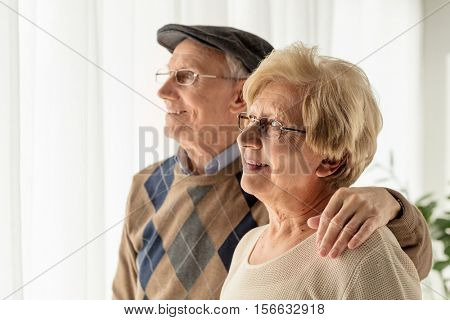 Mature man and woman looking through a window
