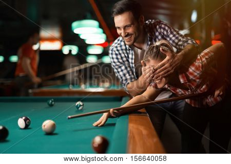 Couple playing snooker, pool and smiling together