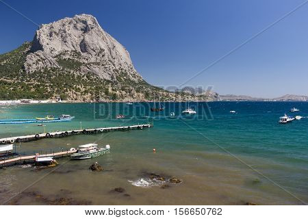 Sea bay surrounded by mountains. Light storm.