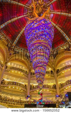 ParisFrance- December 21 2014: Upper part of the Dior stand and the beautiful decorated Christmas decoration in Galleries Lafayette in Paris.