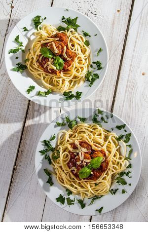 Spaghetti Bolognese for two people on old wooden table