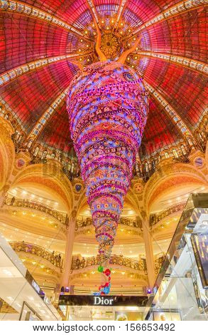 ParisFrance- December 21 2014: Upper part of the Dior stand and the beautiful decorated Christmas decoration in Galleries Lafayette in Paris.
