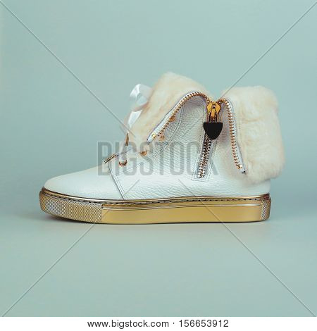 winter female white shoes in blue background