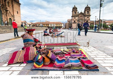  Peru Nov. 9 2015: Unidentified native weavers, dressed in traditional clothing, demonstrate their handicraft. Cusco.