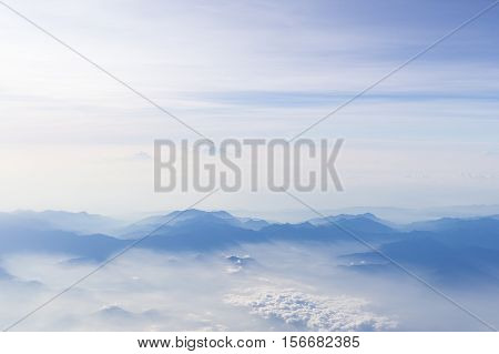 Blue sky and mountains view from airplane stylized hipster background with copyspace.