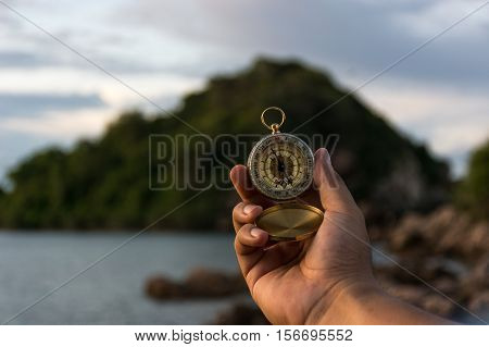 Compass in the hand on the nature background