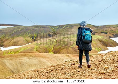 female hiker on the trail in the Islandic mountains. Trek in National Park Landmannalaugar, Iceland