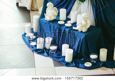 Wedding Decoration Of Blue Satine And White Candles With Little Porcelain Angels
