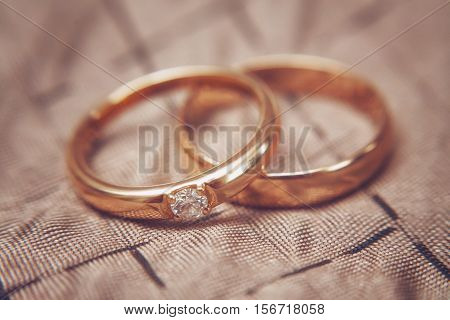 Two beautiful wedding rings with brilliants close up, vintage toned