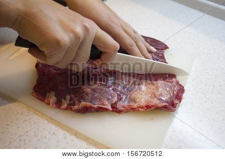 Cutting beef meat in the kitchen. Cooking food