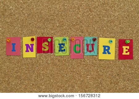 Insecure word written on colorful sticky notes pinned on cork board.