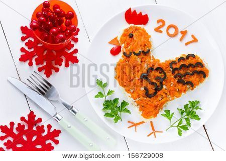 Festive salad shaped rooster or symbol of New Year 2017 on the Chinese calendar. Symbolic food at holiday dinner