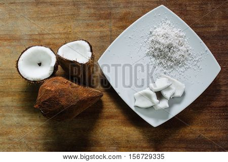 Coconut and coconut grated on a table of wood.