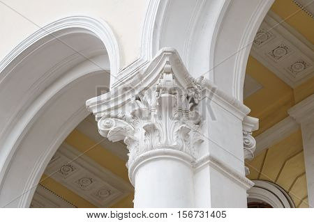 White columns with arches on the facade of the building.