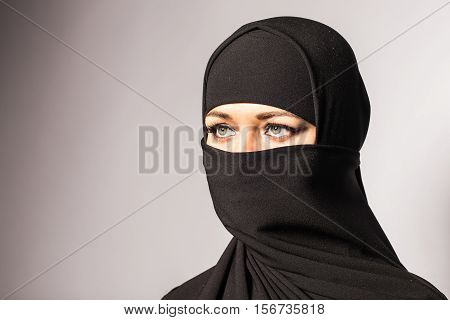 Beautiful Muslim girl wearing black burqa closeup.