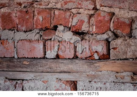 The wooden beams supporting a very old bricks in the wall