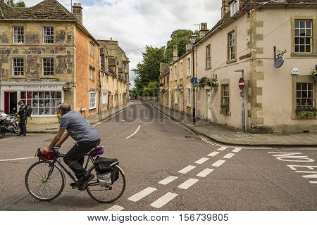 CORSHAM UK: a person rides his bike in a street in Corsham an old village in south of England on July 17 2015 in Corsham UK