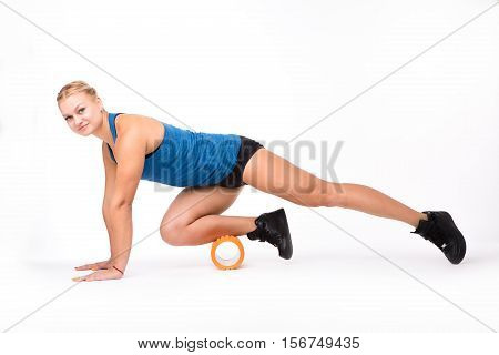 Picture of fitness woman looking at camera while training with massage device isolated on white background instudio. Health concept.