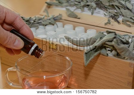 Person gives several drops of medicine into a liquid - close-up