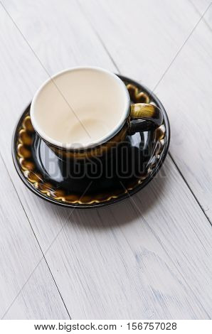 brown cup and saucer on wooden background