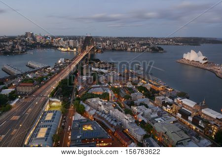 SYDNEY AUS - OCT 20 2016:Aerial urban landscape view of Sydney Harbour with Sydney Harbour Bridge the Opera House Circular Quay and The Rocks with North Sydney in the background at dusk in New South Wales Australia.