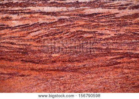 Surface of a red sandstone with white intercalations.