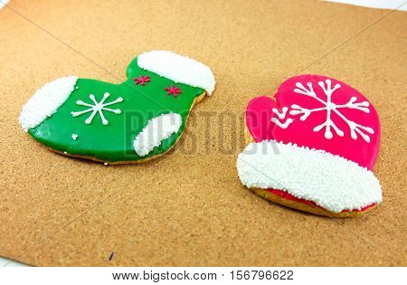 Christmas cookies; green sock and red glove on wodden background