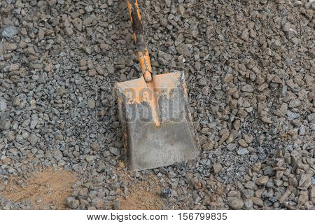 Shovel stuck in a pile of dirt,Construction worker is trying to move a kurb