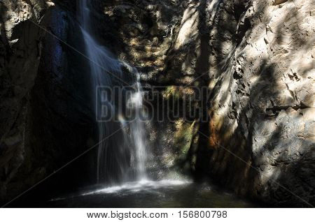 Rainbow at the waterfall Millomeris in the mountains in Cyprus