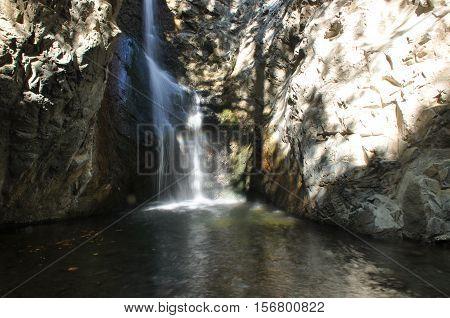 Rainbow at the waterfall Millomeris in the mountains in Cyprus