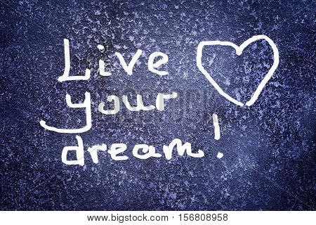 live your dream - motivation reminder on the abstract grunge dark navy background