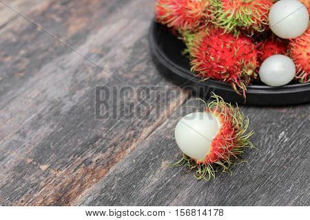 rambutan sweet fruit fresh in plate on wood background :Select focus with shallow depth of field.