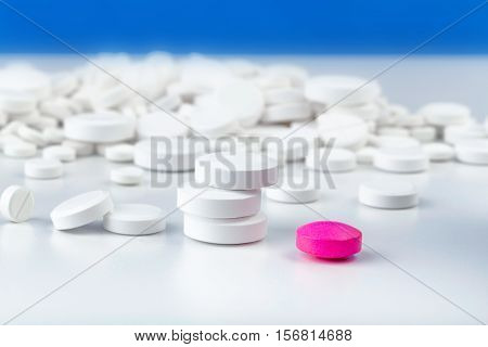 Bunch Of White Tablets. Scattered Pills. Single Pink Pill