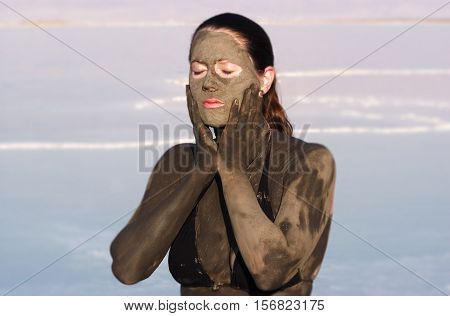 Woman Puts Mineral Beauty Mud On Her Body In The Dead Sea, Israel
