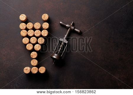 Vintage corkscrew and wine corks on stone table. Top view with copy space