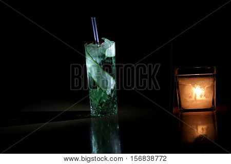 cocktail with candle black backround shaddow light