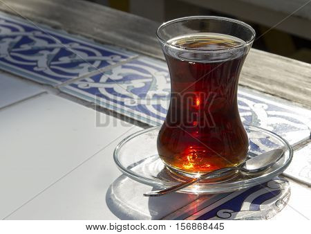 Traditional turkish glass of tea on the old wooden table