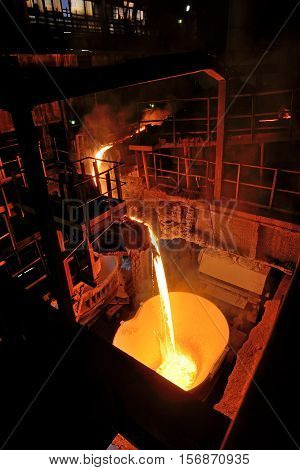 pouring molten steel in steel ladle, close up