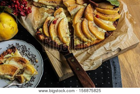 Homemade flour cake with quince and cooking utensils