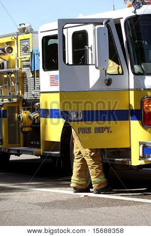 Egy tűzoltó mellette firetruck