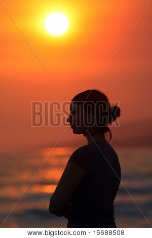 Frau Kontur am Strand bei Sonnenuntergang