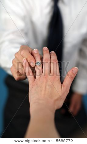 A man proposing and putting a ring on a woman's finger