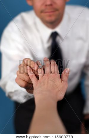 A man proposing and putting a ring on a woman's finger