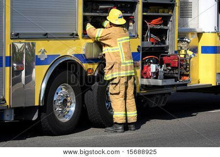 Bombeiro recebendo engrenagem do caminhão de bombeiros