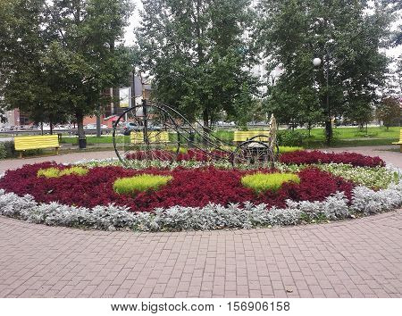 flowerbed with flowers and decorative bicycle in the city