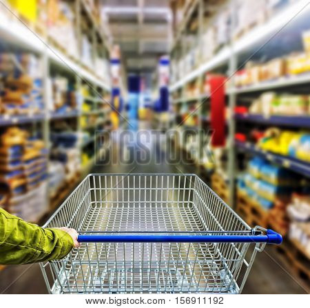 Female customer shopping at supermarket with trolley